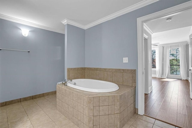 bathroom with tile patterned floors, ornamental molding, and tiled bath