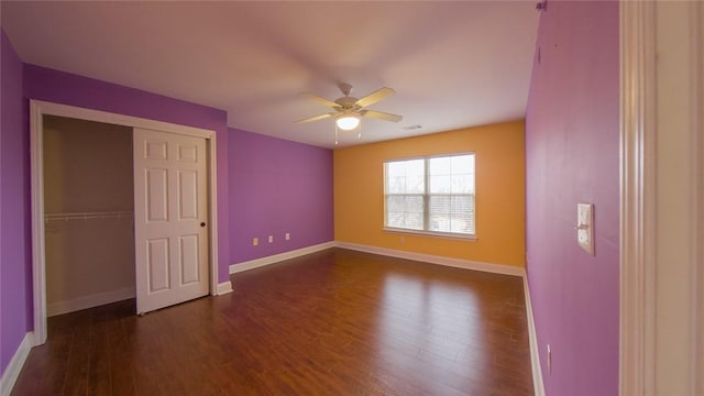 unfurnished bedroom featuring a closet, dark hardwood / wood-style floors, and ceiling fan