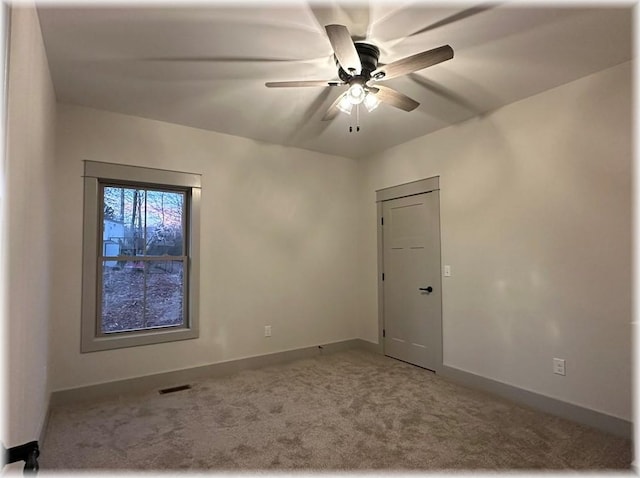 carpeted spare room with ceiling fan