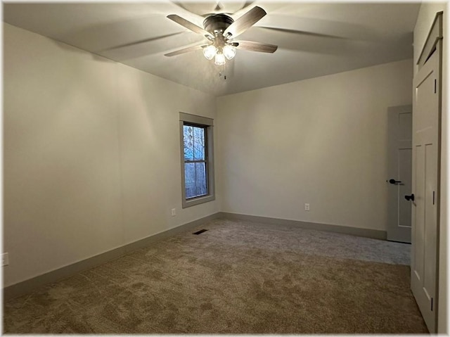 carpeted spare room featuring ceiling fan