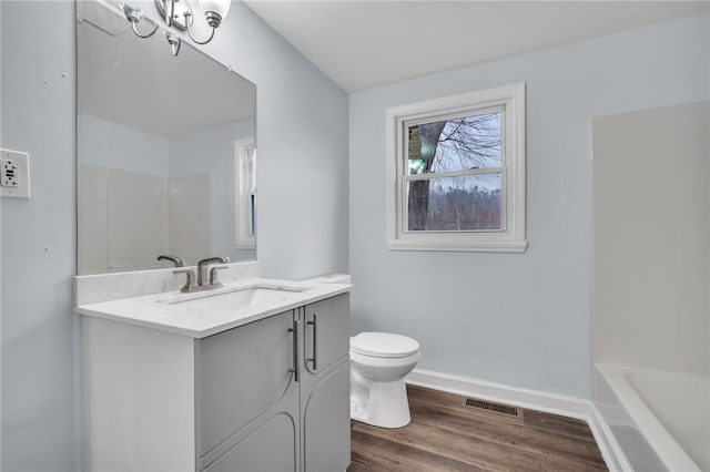 bathroom with hardwood / wood-style flooring, vanity, and toilet