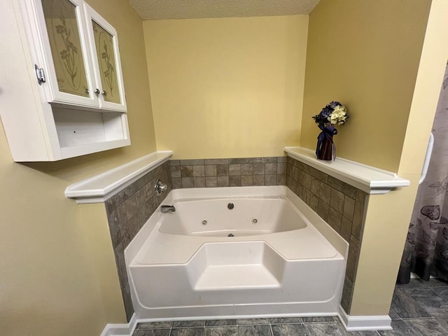 bathroom with a bathtub, a textured ceiling, and tile patterned flooring