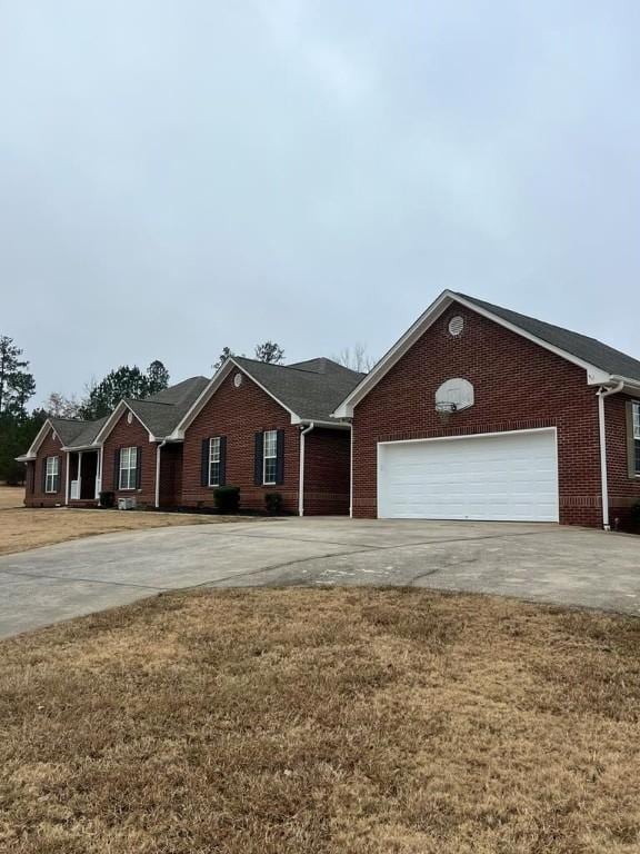 ranch-style house featuring a front yard and a garage