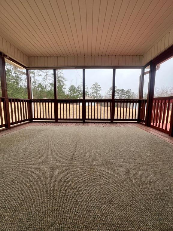 unfurnished sunroom featuring a wealth of natural light and wooden ceiling