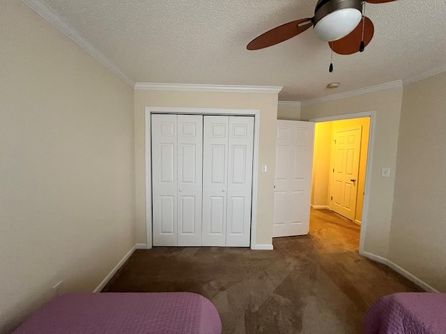 bedroom with ceiling fan, dark colored carpet, crown molding, a textured ceiling, and a closet