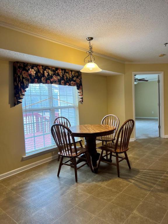 dining room featuring a textured ceiling, ceiling fan, and ornamental molding