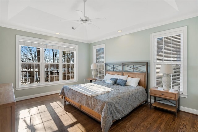 bedroom with dark hardwood / wood-style floors, ceiling fan, and a tray ceiling