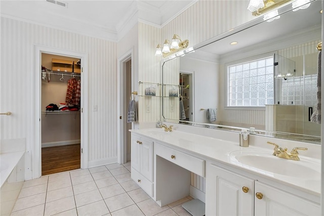 bathroom with tile patterned flooring, vanity, a tub, and crown molding