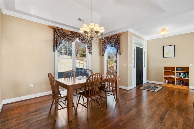 dining space featuring dark hardwood / wood-style floors, crown molding, and a notable chandelier