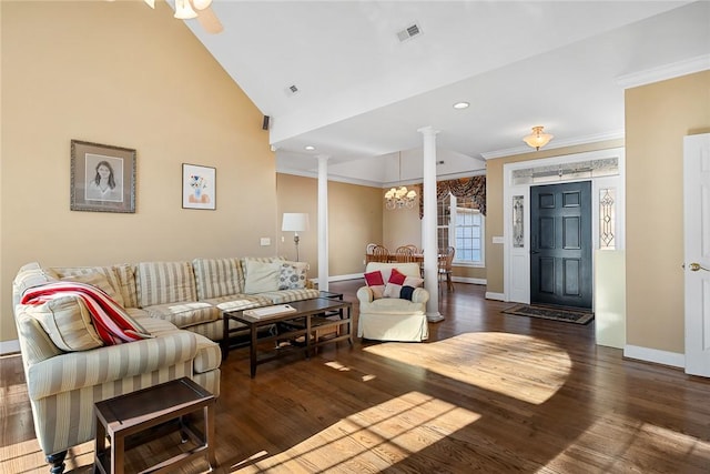 living room featuring ceiling fan with notable chandelier, vaulted ceiling, dark hardwood / wood-style floors, ornamental molding, and decorative columns