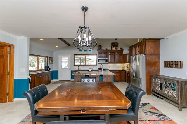 dining room featuring sink, ornamental molding, lofted ceiling, and a notable chandelier