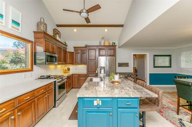 kitchen with a center island with sink, sink, a kitchen bar, and stainless steel appliances