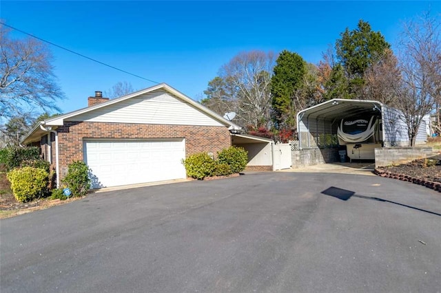 view of side of property featuring a garage and a carport