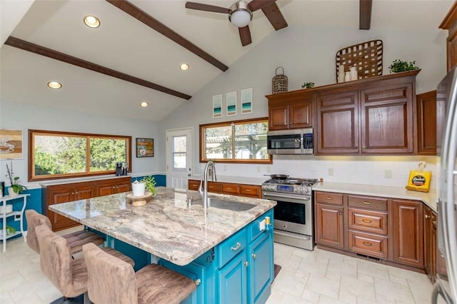 kitchen with a breakfast bar, a kitchen island with sink, sink, tasteful backsplash, and stainless steel appliances