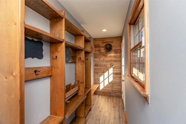 mudroom featuring wood walls and light wood-type flooring