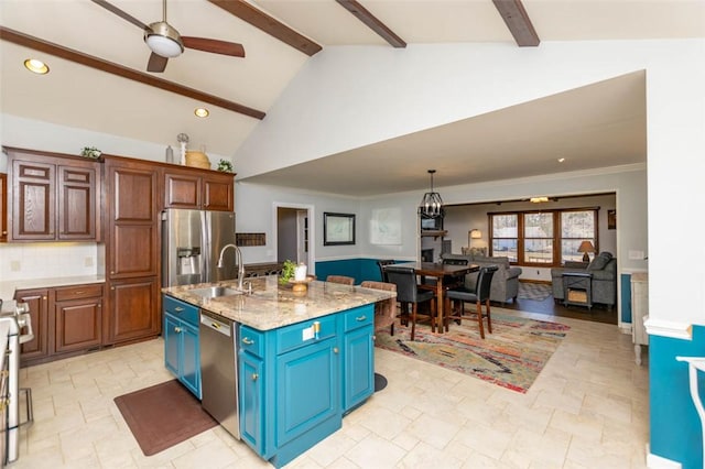 kitchen featuring a center island with sink, ceiling fan, vaulted ceiling with beams, light stone countertops, and stainless steel appliances