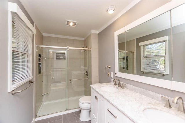 bathroom featuring tile patterned flooring, vanity, toilet, and walk in shower