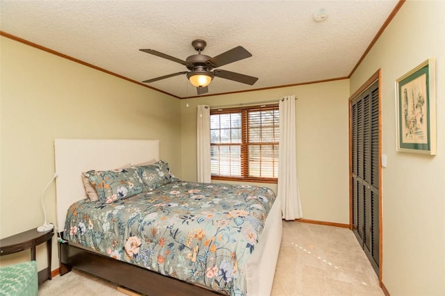 bedroom featuring ceiling fan, light colored carpet, a textured ceiling, and a closet