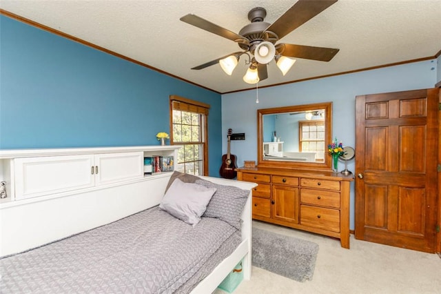 carpeted bedroom featuring ceiling fan, ornamental molding, and a textured ceiling