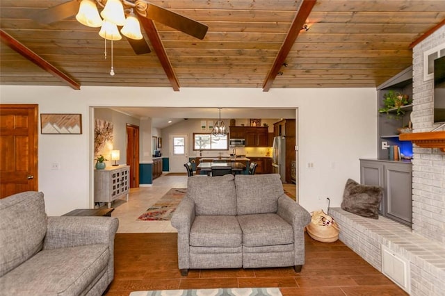 living room with lofted ceiling with beams, ceiling fan, wood ceiling, and a fireplace