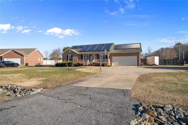 ranch-style home featuring solar panels, a garage, and a front lawn