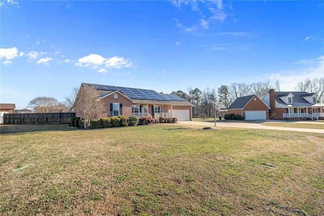 view of front of property featuring solar panels, a garage, and a front yard