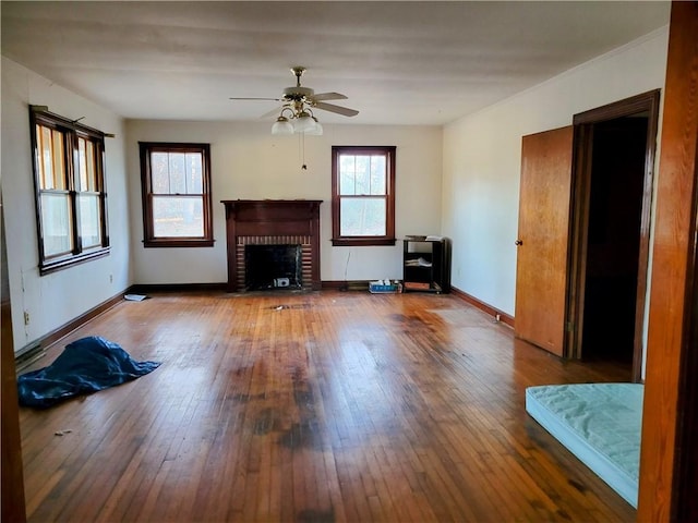 unfurnished living room with a brick fireplace, ceiling fan, and hardwood / wood-style flooring