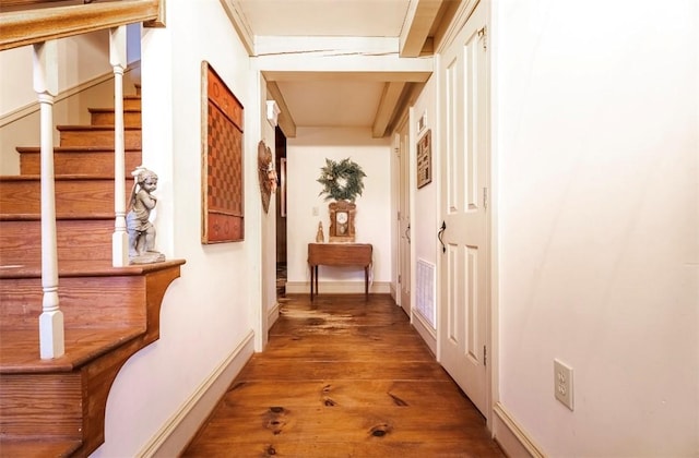 hallway featuring baseboards, visible vents, wood finished floors, and stairs