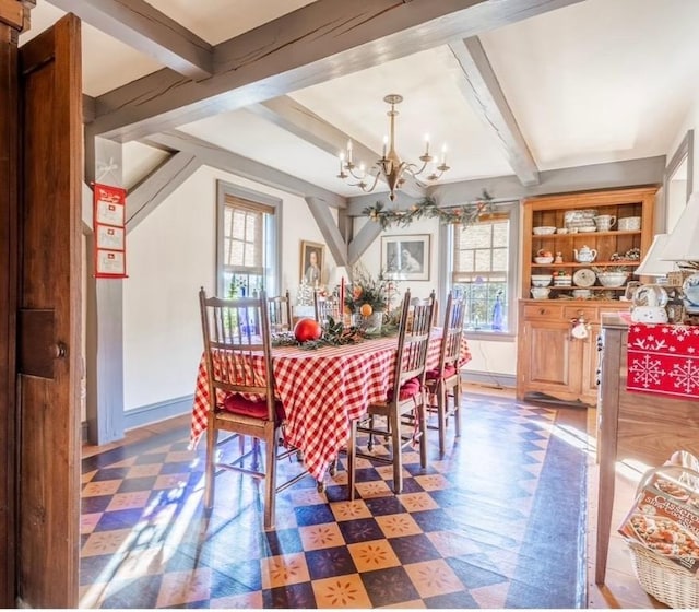 dining room featuring tile patterned floors, beam ceiling, a healthy amount of sunlight, and an inviting chandelier