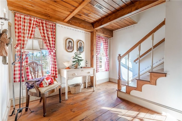 interior space featuring beam ceiling, a healthy amount of sunlight, stairs, and wooden ceiling