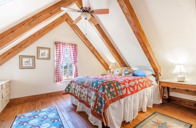 bedroom featuring lofted ceiling with beams, light wood-type flooring, and baseboards