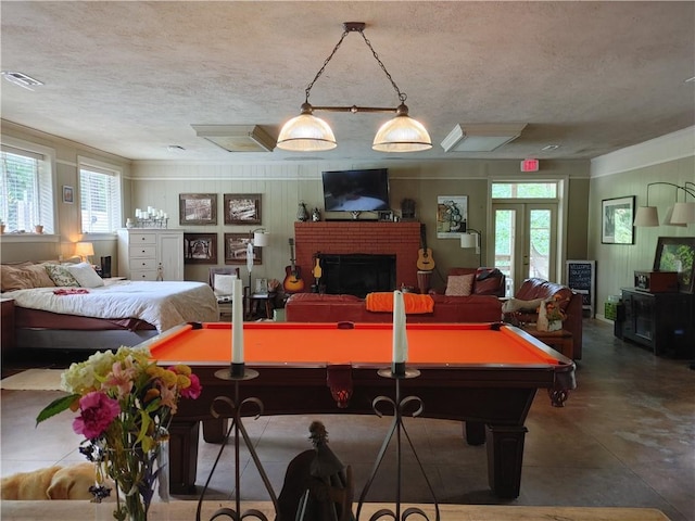 recreation room featuring concrete flooring, a brick fireplace, a wealth of natural light, and pool table