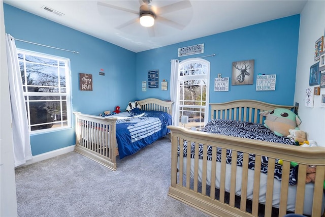 bedroom featuring multiple windows, ceiling fan, and carpet floors