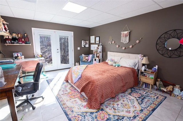 tiled bedroom featuring a paneled ceiling, access to outside, and french doors