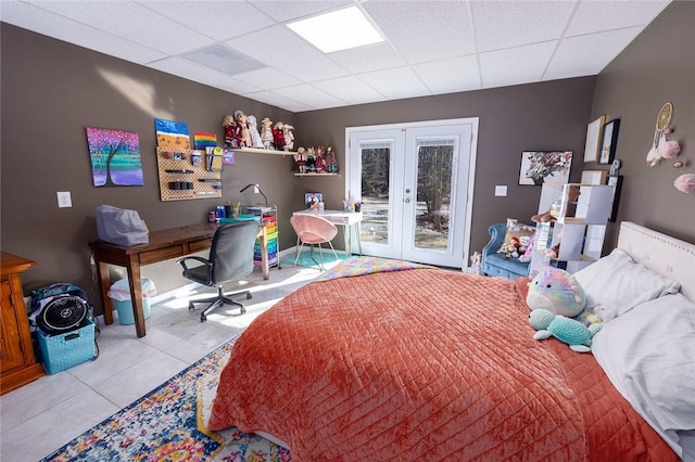 tiled bedroom featuring french doors, a paneled ceiling, and access to outside