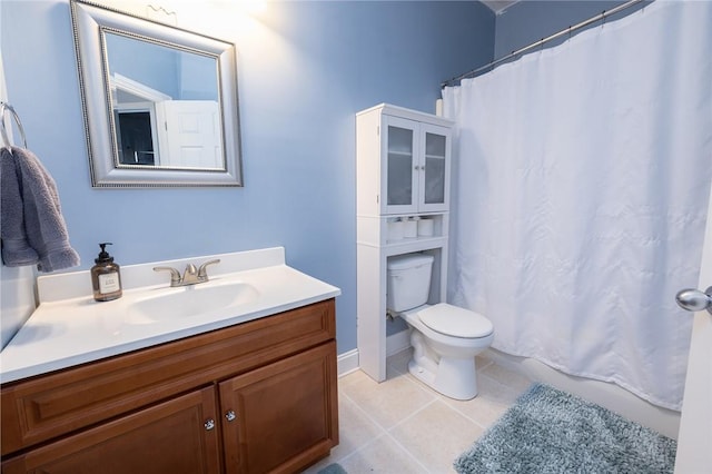 bathroom with toilet, vanity, and tile patterned floors