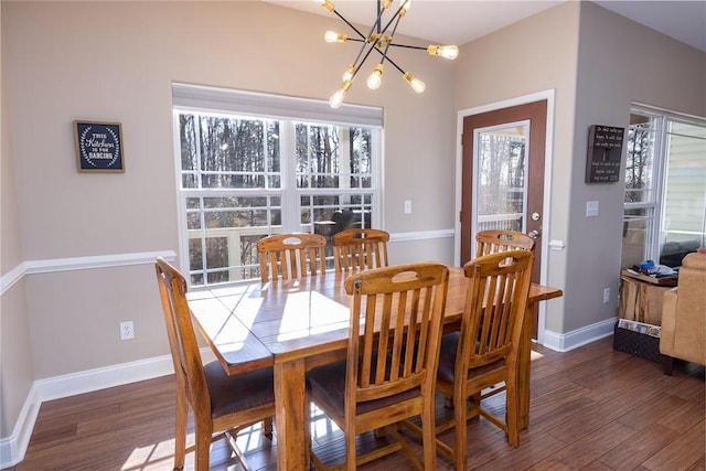 dining area with dark hardwood / wood-style floors and an inviting chandelier