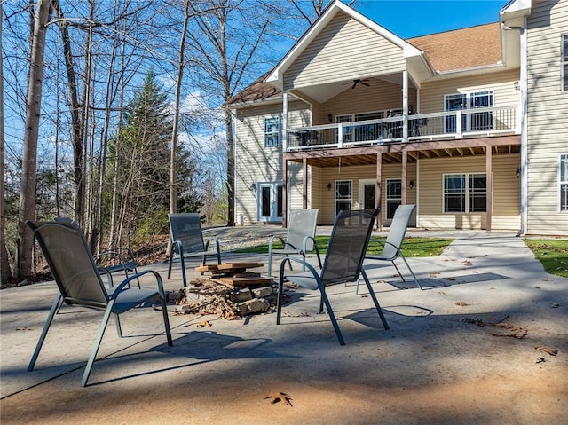 back of property featuring ceiling fan, a patio area, and a balcony