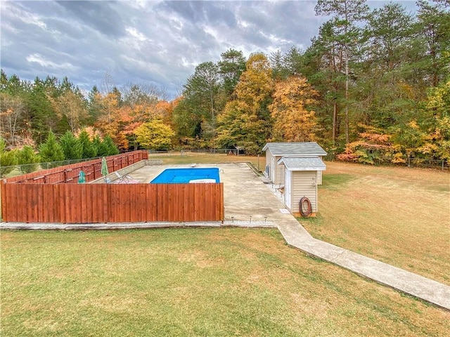 view of pool with a storage unit and a lawn