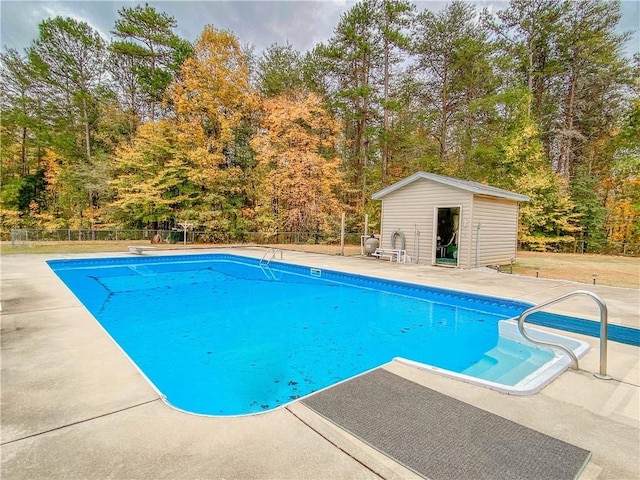 view of swimming pool with an outbuilding and a patio