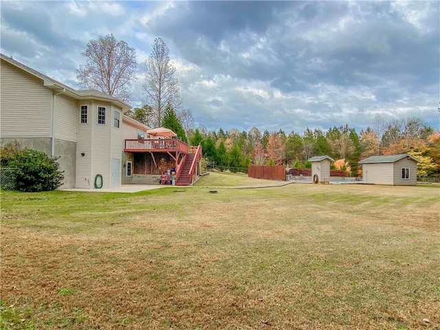 view of yard with a storage unit, a patio area, and a deck