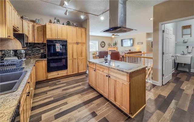 kitchen featuring a center island, dark wood-type flooring, electric cooktop, black double oven, and island range hood