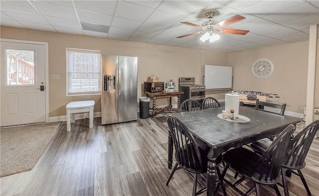 dining space featuring hardwood / wood-style floors, a paneled ceiling, and ceiling fan