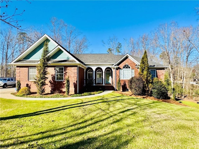 ranch-style home with covered porch and a front yard