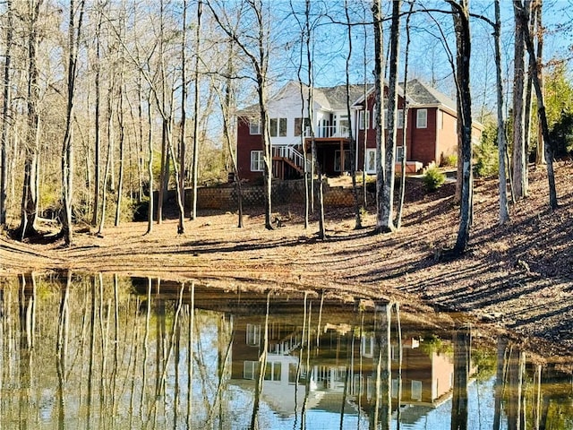 rear view of house featuring a deck with water view