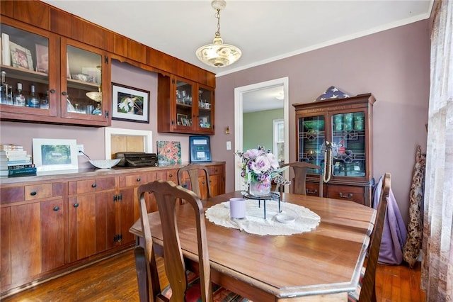 dining area featuring crown molding and dark hardwood / wood-style flooring