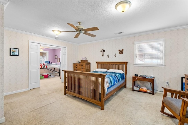 carpeted bedroom with a textured ceiling, ceiling fan, and crown molding