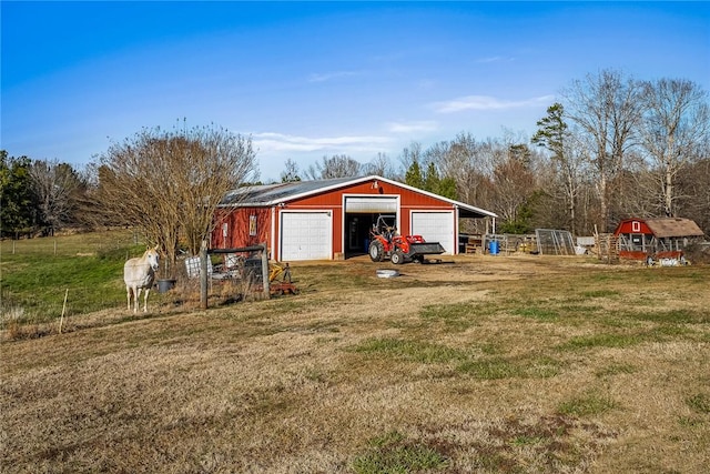 view of yard featuring a garage and an outdoor structure