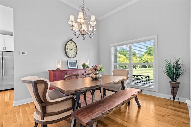 dining area with light hardwood / wood-style floors, an inviting chandelier, and crown molding