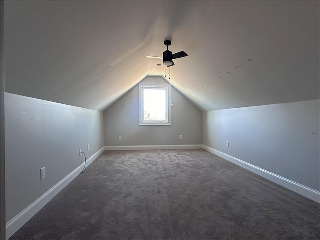 additional living space with ceiling fan, vaulted ceiling, and dark colored carpet